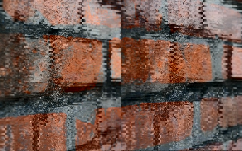 Close up photo of a brown brick wall