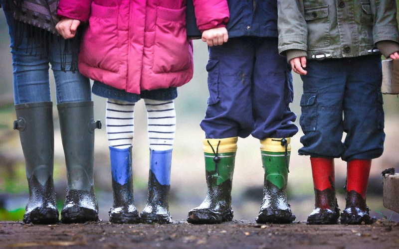 Four children wearing muddy boots