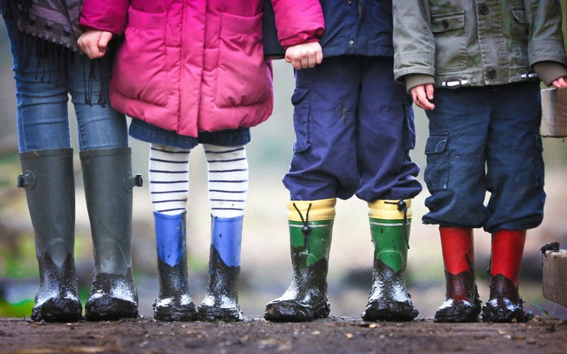 Four children wearing muddy boots